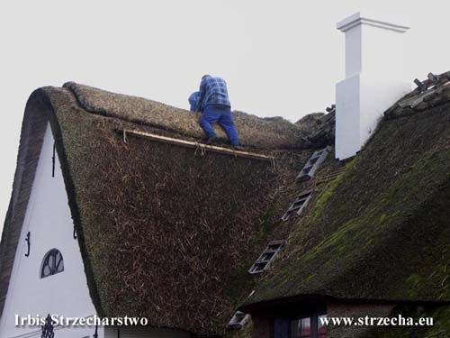 Service of thatched roofs - filling the straw ridge with new material
